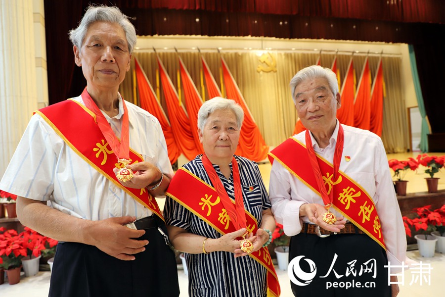 3位黨齡達到50年的老黨員代表與他們的“光榮在黨50年”紀念章。人民網 王文嘉攝